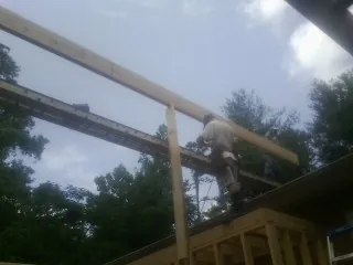 Carpenter setting a ridge beam over a new addition frame — Ice Dam Removal by Roofing Brothers in Winthrop